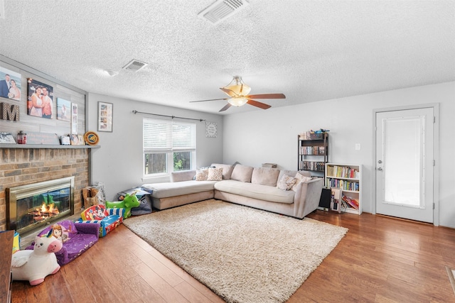 4212 Selina Ct, Arlington, TX 76016 - living room featuring wood finished floors, ceiling fan, a fireplace, and a textured ceiling