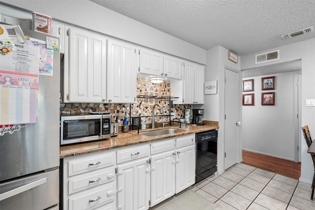 4212 Selina Ct, Arlington, TX 76016 - kitchen with stainless steel appliances, a sink, a textured ceiling, white cabinetry, and light tile patterned floors