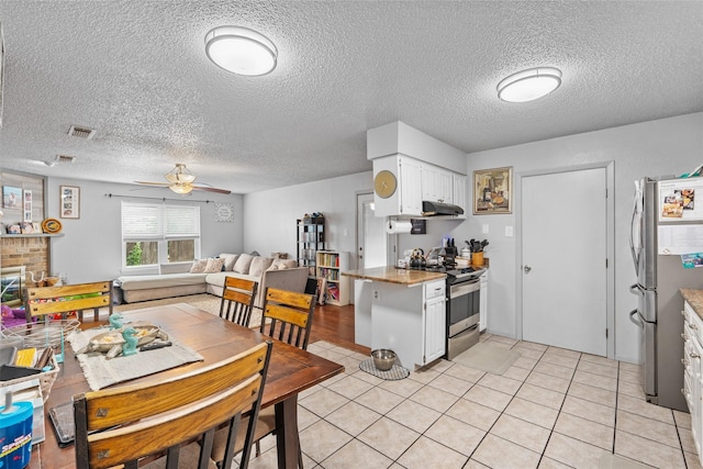 4212 Selina Ct, Arlington, TX 76016 - kitchen with stainless steel appliances, ceiling fan, white cabinets, a textured ceiling, and light tile patterned flooring