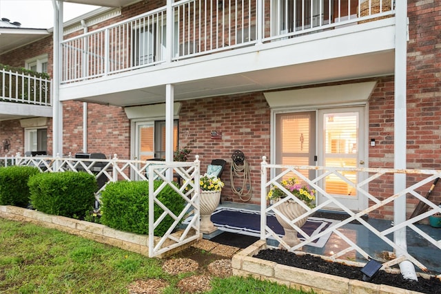 property entrance featuring brick siding and a balcony