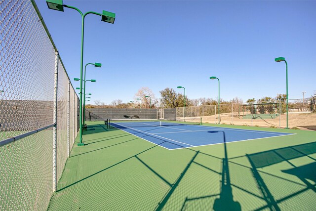 view of tennis court with fence and community basketball court