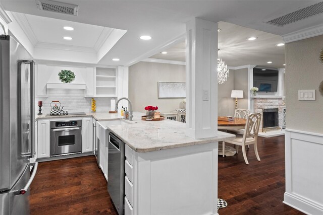 kitchen featuring crown molding, appliances with stainless steel finishes, open shelves, and visible vents