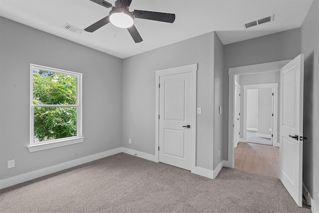 unfurnished bedroom featuring carpet flooring, a ceiling fan, baseboards, and visible vents