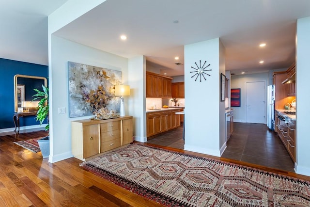 hallway with dark wood-type flooring, recessed lighting, and baseboards