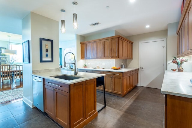 kitchen with visible vents, stainless steel dishwasher, brown cabinets, tasteful backsplash, and a sink