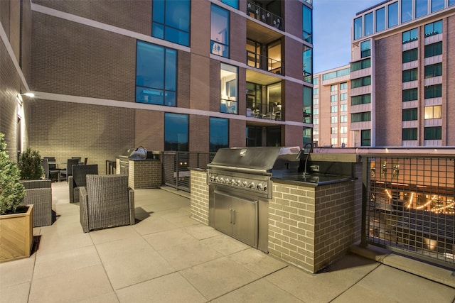 view of patio / terrace featuring exterior kitchen and a grill