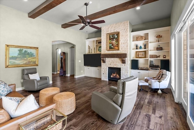 8230 County Road 530, Mansfield, TX 76063 - living area featuring a ceiling fan, dark wood-style flooring, a stone fireplace, arched walkways, and beam ceiling