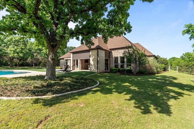 8230 County Road 530, Mansfield, TX 76063 - rear view of property with fence, stone siding, a patio, an outdoor pool, and a yard