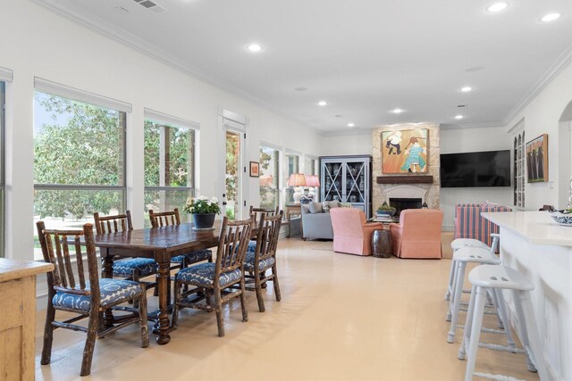 dining room with crown molding, a fireplace, recessed lighting, and visible vents