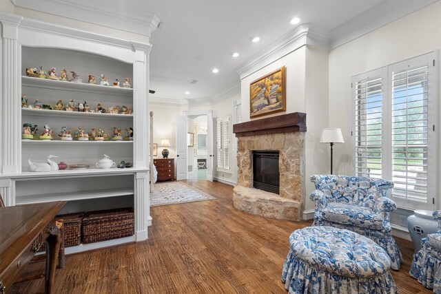 living room featuring a fireplace, wood finished floors, baseboards, ornamental molding, and recessed lighting
