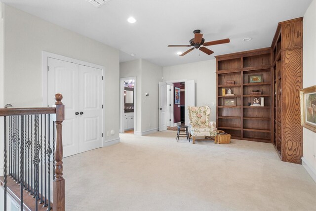 sitting room featuring carpet flooring, a ceiling fan, baseboards, recessed lighting, and an upstairs landing