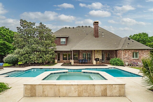 view of pool with a patio and a pool with connected hot tub