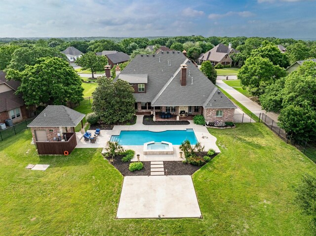 view of swimming pool with a residential view, a pool with connected hot tub, a fenced backyard, a patio area, and a yard