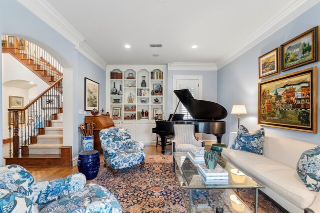 living room featuring ornamental molding, stairs, wood finished floors, and built in features
