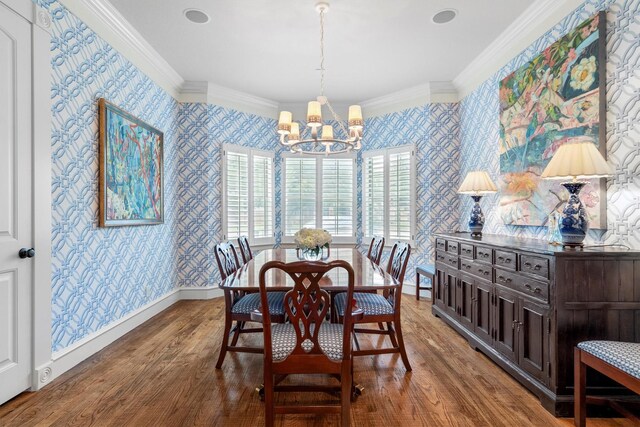 dining room featuring crown molding, wallpapered walls, a notable chandelier, and wood finished floors