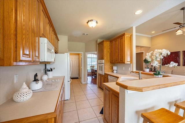 265 Old Spanish Trl, Valley View, TX 76272 - kitchen with a peninsula, light tile patterned flooring, white appliances, a kitchen bar, and a sink