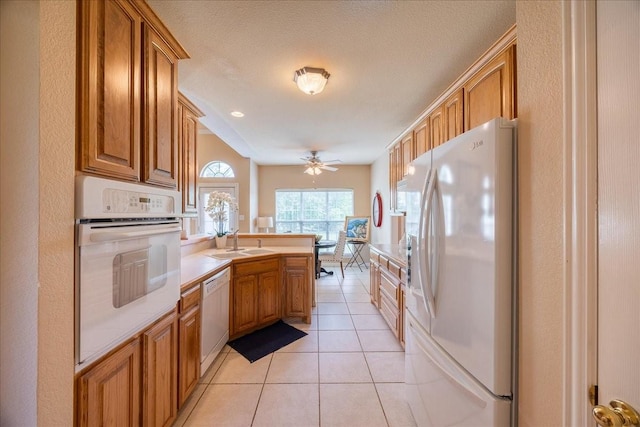 265 Old Spanish Trl, Valley View, TX 76272 - kitchen with white appliances, a peninsula, brown cabinets, and a sink
