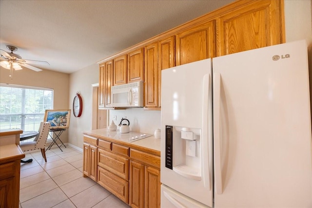 265 Old Spanish Trl, Valley View, TX 76272 - kitchen featuring light tile patterned flooring, ceiling fan, white appliances, light countertops, and brown cabinetry