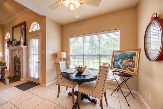 265 Old Spanish Trl, Valley View, TX 76272 - dining area featuring a ceiling fan, a tiled fireplace, baseboards, ornamental molding, and light tile patterned flooring