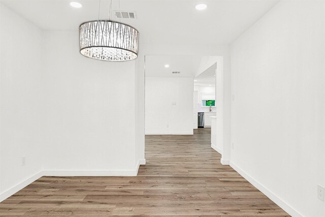 hallway with recessed lighting, baseboards, visible vents, and light wood-style floors