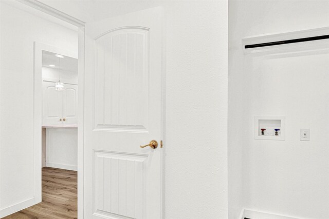 laundry room with laundry area, hookup for a washing machine, and wood finished floors
