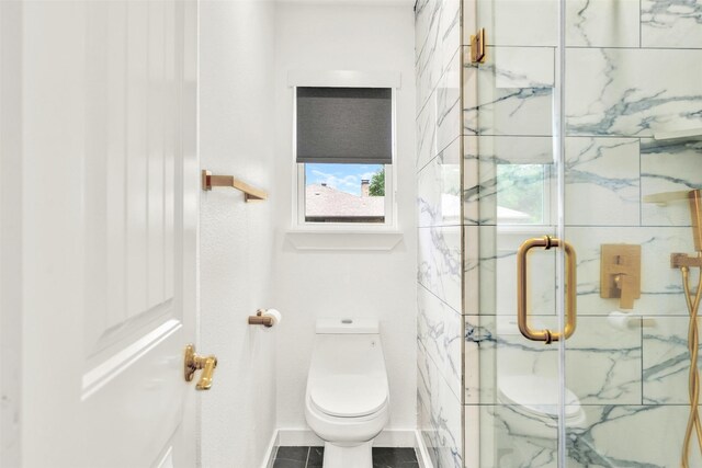 full bathroom featuring a marble finish shower, baseboards, and toilet