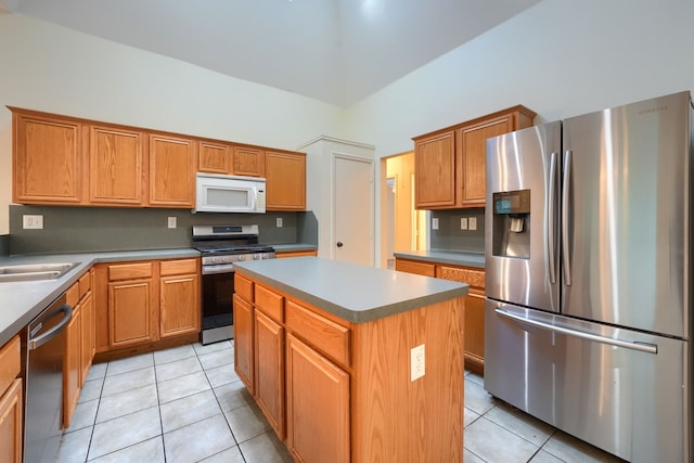 9104 Chesapeake Ln, Mckinney, TX 75071 - kitchen with stainless steel appliances, a towering ceiling, light tile patterned floors, a kitchen island, and a sink