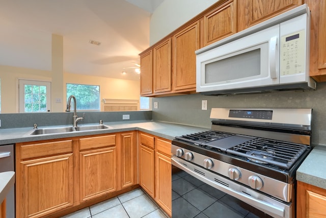 9104 Chesapeake Ln, Mckinney, TX 75071 - kitchen featuring stainless steel appliances, a sink, light tile patterned floors, ceiling fan, and brown cabinets
