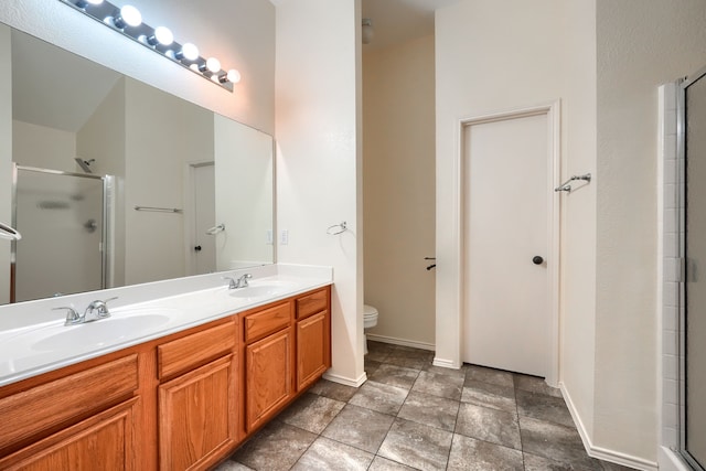 9104 Chesapeake Ln, Mckinney, TX 75071 - bathroom with a stall shower, toilet, double vanity, and baseboards