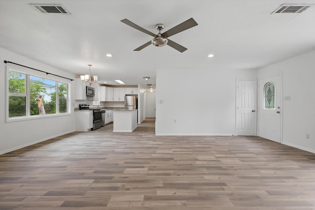 unfurnished living room with recessed lighting, baseboards, visible vents, and light wood-type flooring