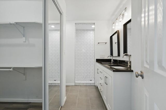 bathroom featuring a sink, tile patterned floors, a shower stall, and double vanity