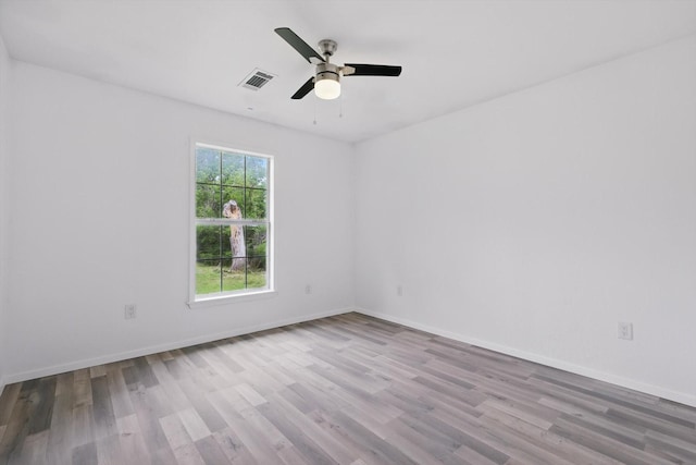 spare room featuring baseboards, a ceiling fan, wood finished floors, and visible vents