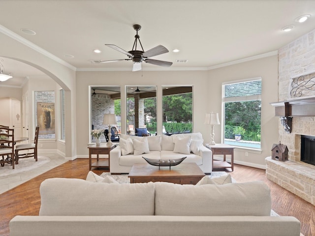 10 Tennis Village Dr, Heath, TX 75032 - living area with arched walkways, a fireplace, a ceiling fan, crown molding, and baseboards