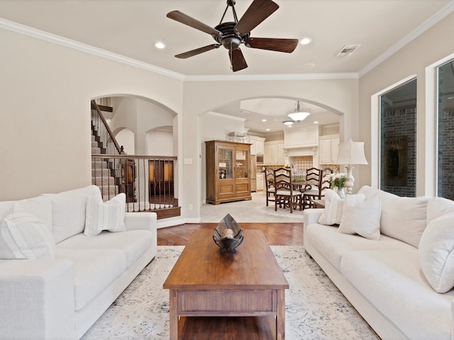 10 Tennis Village Dr, Heath, TX 75032 - living area featuring arched walkways, crown molding, stairs, a ceiling fan, and light wood finished floors