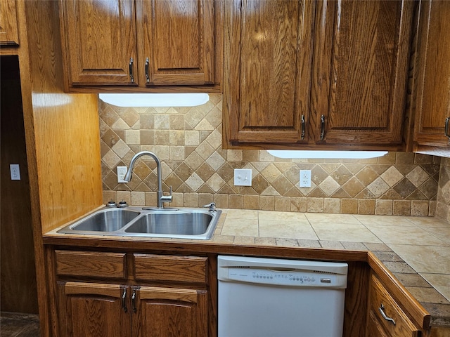 kitchen with a sink, decorative backsplash, and dishwasher