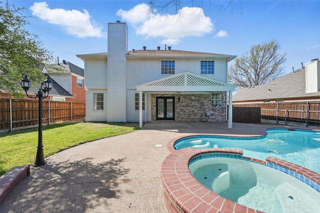 back of house with a lawn, a fenced backyard, a patio area, and french doors