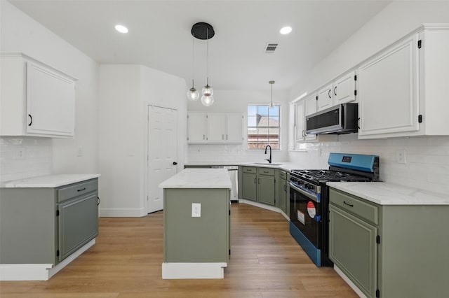 kitchen featuring a sink, green cabinetry, tasteful backsplash, and stainless steel appliances