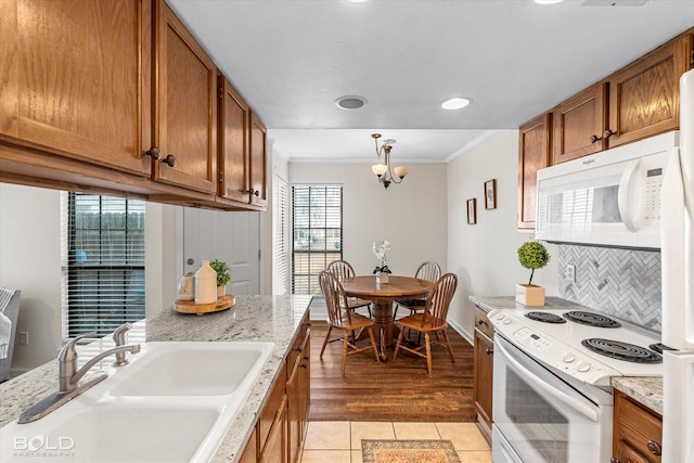 284 Settlers Park Dr, Shreveport, LA 71115 - kitchen featuring brown cabinetry, backsplash, crown molding, a sink, and white appliances