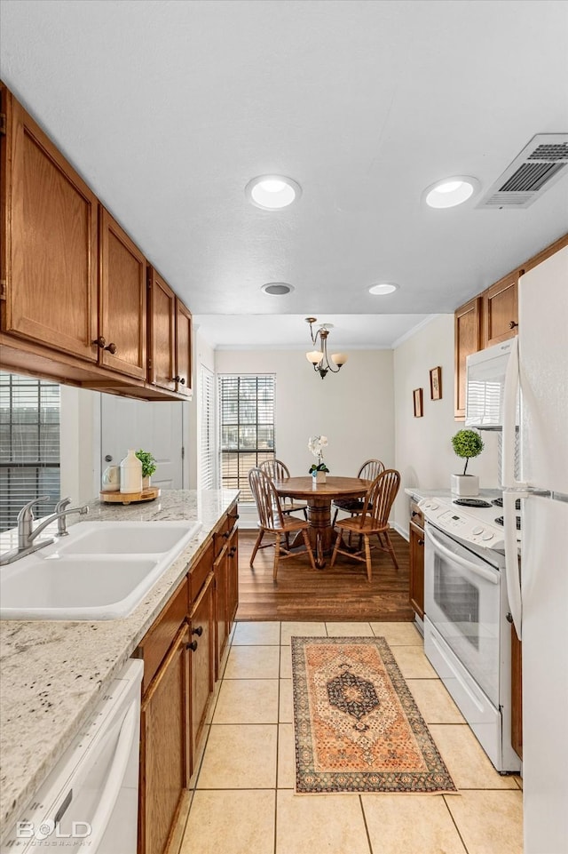 284 Settlers Park Dr, Shreveport, LA 71115 - kitchen with brown cabinets, a sink, white appliances, light tile patterned floors, and visible vents