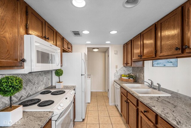 284 Settlers Park Dr, Shreveport, LA 71115 - kitchen featuring backsplash, brown cabinets, a sink, light tile patterned floors, and white appliances