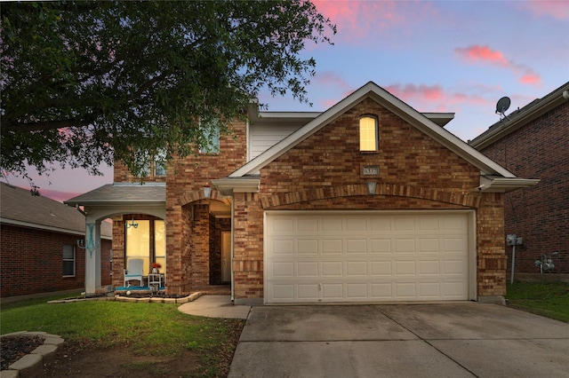 traditional-style home with concrete driveway, brick siding, a yard, and a garage