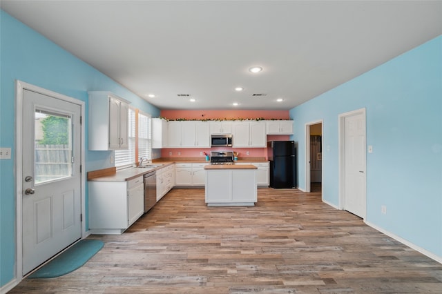kitchen featuring visible vents, a sink, light wood finished floors, and appliances with stainless steel finishes
