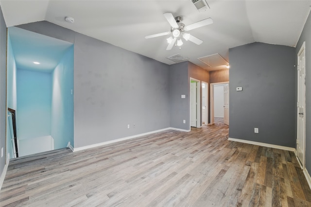 interior space with visible vents, lofted ceiling, wood finished floors, and attic access