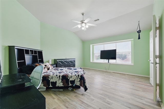 bedroom featuring ceiling fan, visible vents, vaulted ceiling, wood finished floors, and baseboards