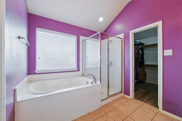 full bath with tile patterned floors, a stall shower, a garden tub, and lofted ceiling