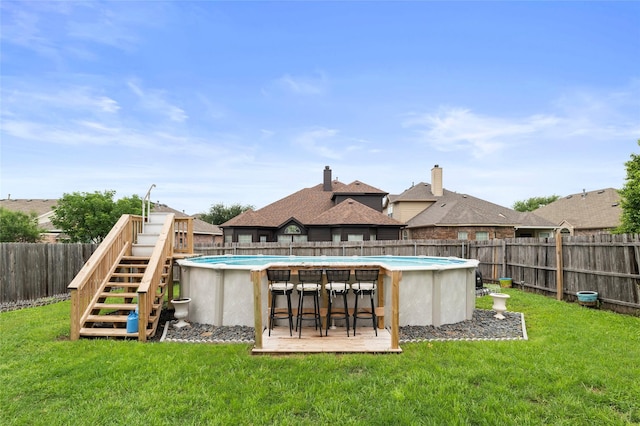 rear view of house with stairway, a yard, a fenced in pool, and a fenced backyard