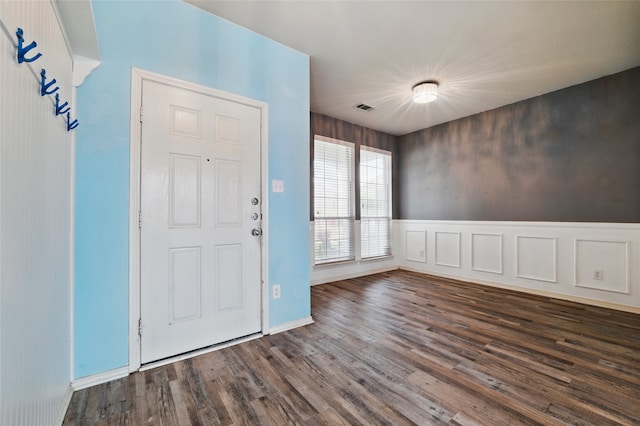 foyer entrance with baseboards, visible vents, and wood finished floors