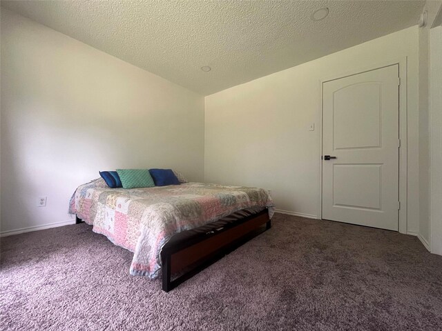bedroom with baseboards, carpet flooring, and a textured ceiling