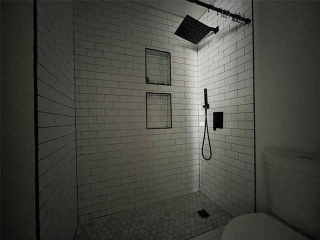 bathroom featuring a shower stall and toilet