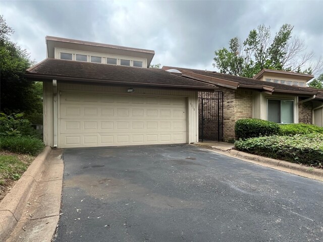 view of front facade featuring a garage and aphalt driveway